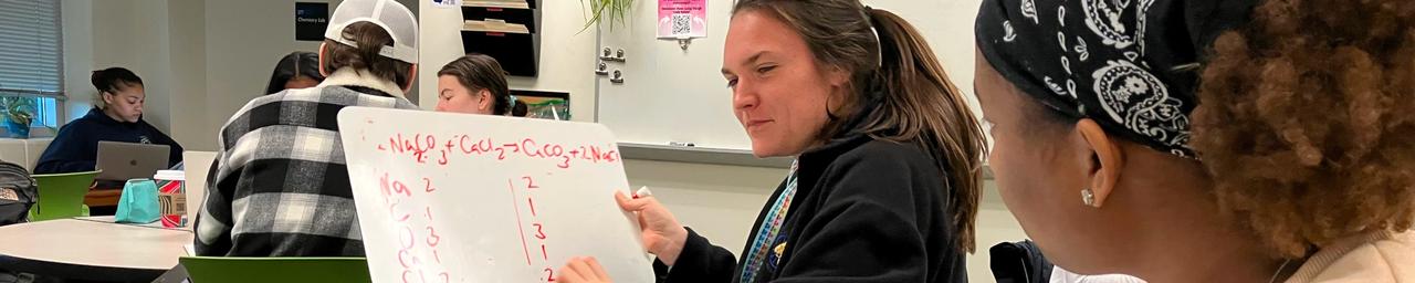 Student tutor at the Chemistry Success Center holds a whiteboard
